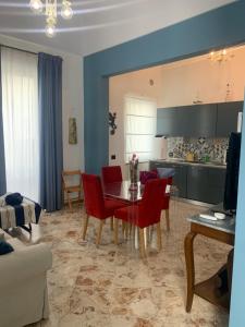 加拉蒂纳Appartamento Primitivo的客厅配有桌子和红色椅子