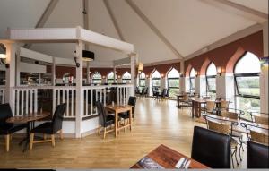 佩恩顿Luxury Lodge - Hoburne Devon Bay的餐厅设有木桌、椅子和窗户。