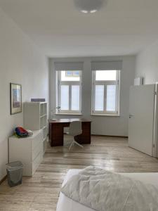 瓦尔堡Apartment Van Eß Hof - Altstadt Warburg的白色的客房配有书桌和床。