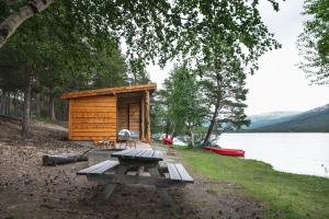 LesjaskogLesjaskogsvatnet Camping的湖畔小屋前的野餐桌