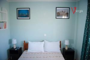 普雷韦扎OLIVES Estate APARTMENTS Grande的卧室配有一张床,墙上挂有两张照片