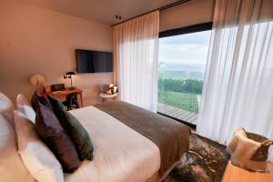 MutignyLOISIUM Wine & Spa Hotel Champagne的一间卧室设有一张床和一个大窗户