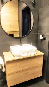 绿山城Drzewna Apartamenty -Augustowska的一间带水槽和镜子的浴室