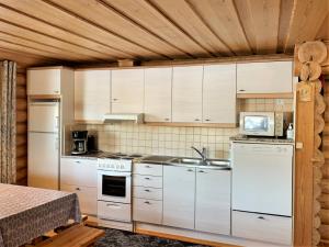 普马拉Lappalaisen lomamökit Lepola的一间厨房,配有白色家电和木制天花板