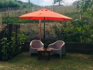 法尔肯堡Auberge Sans Souci的两张椅子和一张带雨伞的桌子