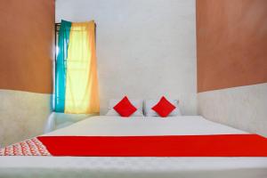 坤甸OYO 91051 Penginapan Pondok Ratu 354的一张带两个红色枕头的床