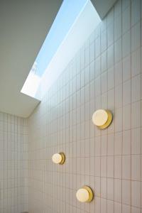 法鲁Bougainvillea 33 by My Cozy Home的白色瓷砖浴室设有天窗