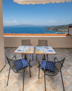 圣托斯特凡诺港Residence Sole Dell'Argentario的阳台上摆放着两张桌子和两把椅子,