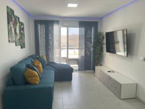 库拉海滩Monsenor的客厅配有蓝色的沙发和桌子