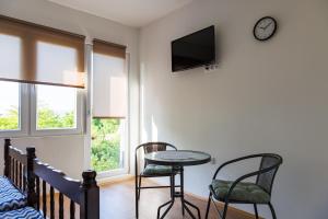 哥鲁拜克Vila Peristeron的一间设有桌子、两把椅子和时钟的房间