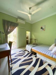 淡马鲁Darney's Homestay Kg Bangau Tanjung的一间卧室配有两张床、一张桌子和一张地毯。