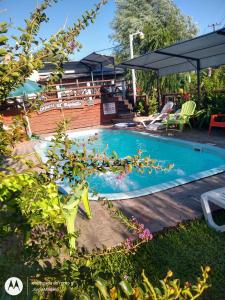 科隆Complejo El Espinillo的庭院内的游泳池,配有桌椅