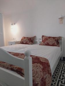 哈马马特Dar Fatma的卧室内的白色床和红色枕头