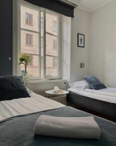 斯德哥尔摩Lilla Brunn的酒店客房设有两张床和窗户。