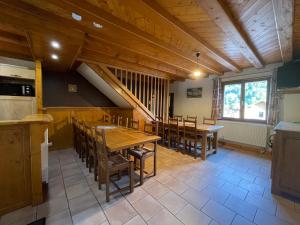 旺特龙Le Logis du Kos的厨房以及带木桌和椅子的用餐室。