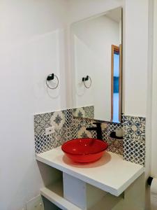 莱瓦镇OFF HOSTEL的浴室在带镜子的柜台上装有红色碗