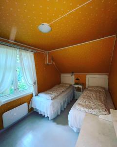 莱达尔绥里Aobrio Holidayhouse, authentic norwegian farmhouse close to Flåm的橙色墙壁客房的两张床