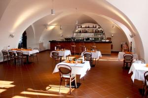 Velká Bystřice瓦尔卡比斯特采萨梅克酒店的餐厅设有白色的桌椅和柜台