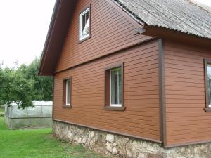 AlatskiviKalamehe Farmstay的一间红色的房子,两边有三个窗户