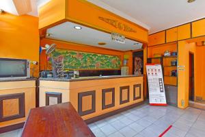 登巴萨OYO 3244 Grand Chandra Hotel的厨房设有橙色的墙壁、水槽和柜台。