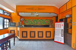 登巴萨OYO 3244 Grand Chandra Hotel的带橙色墙壁的厨房和带柜台的厨房