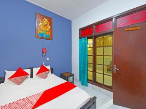 登巴萨OYO 3244 Grand Chandra Hotel的一间卧室设有一张红色和蓝色的墙壁床。