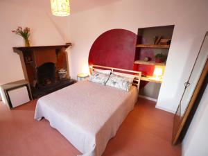 曼德洛德拉廖Il Mallo Verde - Lake Como B&B的一间卧室配有一张带红色床头板的床和一个壁炉