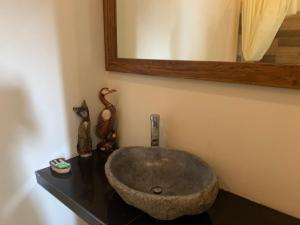 乌布陆上奇迹别墅旅馆的一间带石制水槽和镜子的浴室