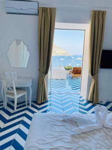 波西塔诺Villa Diamond Luxury Suite的一间卧室配有一张床、一张桌子和一个窗户。