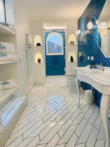 波西塔诺Villa Diamond Luxury Suite的蓝色和白色的浴室设有水槽和浴缸。
