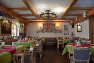 库罗阿尔滕堡贝伦费尔斯自然酒店的餐厅设有绿色桌椅和吊灯。