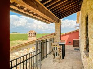 拉戈堡Villaluce Wine Agriturismo的阳台配有桌子,享有田野美景