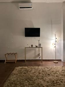 特科早特拉Suite Copal的一间客厅,在白色的墙上配有电视