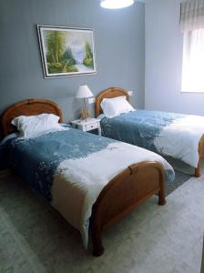 巴雷罗斯Apartamento Playa de Coto的一间卧室设有两张床和一张桌子上的台灯。
