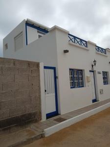 塞博河畔卡莱塔Casa El Salao的白色的房子,有蓝色的门和砖墙