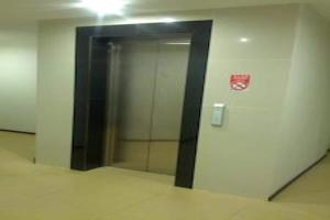 米里Super OYO 90579 U Inn的一座带玻璃门的办公楼里的电梯
