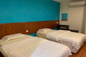 米里Super OYO 90579 U Inn的一间设有两张床和蓝色墙壁的客房