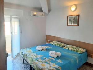 里米尼阿马尔菲酒店的一间卧室配有蓝色的床和毛巾