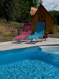 龙尚Insolite avec piscine Au Bonheur Comtois的游泳池旁的甲板上摆放着两把椅子
