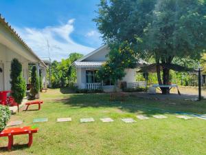 Ban Bo Wiบ้านไม้หอมบูติค สวนผึ้ง的一个带野餐桌和房子的院子