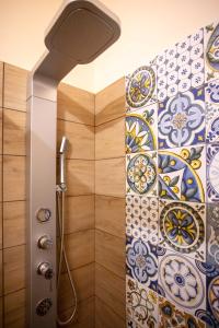 AlianoIl Paesaggio Lunare的带淋浴头和瓷砖墙的淋浴
