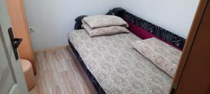 新瓦罗什Vila Vasojević的一张小床,里面放着两个枕头