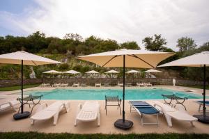 AlianoIl Paesaggio Lunare的一个带桌椅和遮阳伞的游泳池