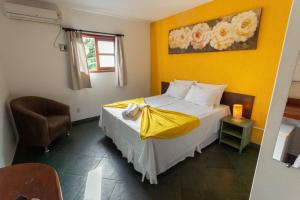 博尼图Pousada Céu de Estrelas的一间卧室配有一张黄色墙壁的床