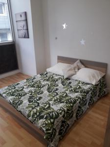 丁香镇LES LILAS的床上铺有绿色和白色的毯子