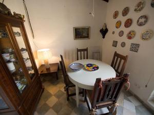 阿尔啼Guest House Bellaguarda的一间墙上配有桌椅和盘子的用餐室