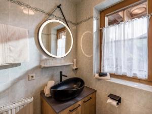 瑟尔Alpengasthof Gruberhof的浴室设有黑色水槽和镜子