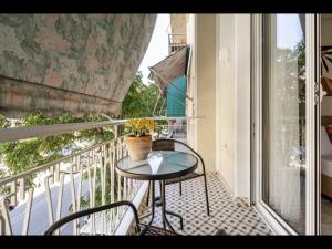 雅典Pagrati, Rizari的阳台配有桌椅和窗户。