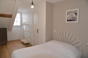卢瓦尔河畔默恩DNJ Appart Hotel的卧室配有白色的床和梯子