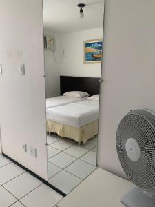 巴雷里尼亚斯GRAN LENÇÓIS FLAT - APTO PARTICULAR的一间卧室配有一张床和镜子内的风扇
